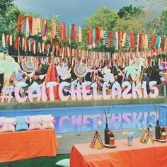 there are many decorations on the wall next to the pool that is decorated with streamers