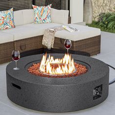 a fire pit sitting on top of a patio next to a couch and coffee table