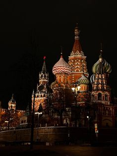 the cathedral is lit up at night with lights on it's domes and spires