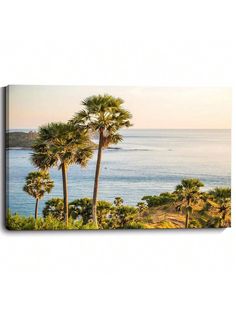 two palm trees on the shore of a body of water with an island in the background