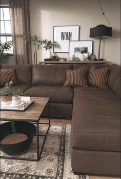 a living room with a large sectional couch and coffee table in front of the window