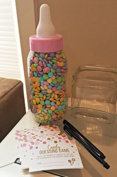 a bottle filled with candy sitting on top of a table next to a notepad