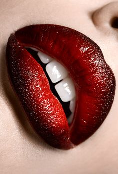 a woman's lips with red lipstick and white teeth are seen in this close up photo