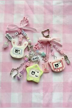 several different key chains on a pink and white checkered table cloth