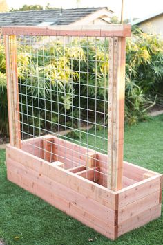 a wooden planter filled with plants on top of grass