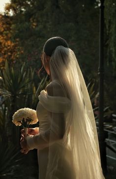 a woman in a wedding dress holding a bouquet of flowers