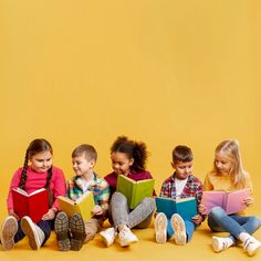 five children are sitting on the floor and one is reading books while the other sits down