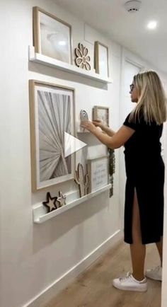 a woman is looking at some artwork on the wall