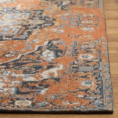 an orange and blue rug on a wooden floor with a wood floor in the background