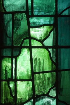 a close up view of a stained glass window with green and blue paint on it