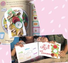 two children are holding up their books in front of them