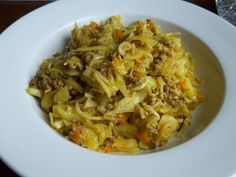 a white plate topped with pasta and meat