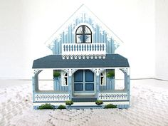 a blue and white doll house sitting on top of snow covered ground