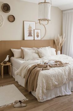 a bedroom with a bed, rugs and pictures hanging on the wall above it