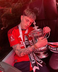 a man sitting in the back seat of a car holding a trophy