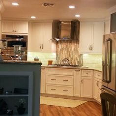 a kitchen with white cabinets and stainless steel appliances