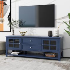 a television is mounted on the wall next to a blue cabinet and potted plant