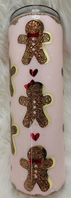 a pink and gold glittered can cooler with two gingerbreads on the side