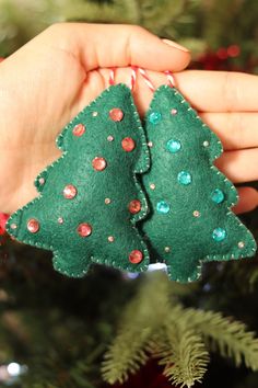 a hand holding a green christmas tree ornament