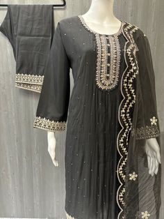 Made from sumptuous Roman Silk, this black party wear silk kurti set is the epitome of elegance and sophistication. The intricate work on the kurti adds a touch of glamour, making it perfect for any special occasion. Available in size 42/46, this premium quality outfit comes with a stunning organza dupatta to complete the look. With its luxurious fabric and exquisite detailing, this kurti set is sure to make a statement at any event. Whether it's a wedding, festival, or other celebration, you'll Elegant Cotton Silk Kurta With Dori Work, Elegant Silk Palazzo Set With Dori Work, Elegant Cotton Silk Sharara For Celebration, Silk Straight Kurta With Dori Work, Elegant Silk Kurta With Dori Work, Elegant Embroidered Cotton Silk Churidar, Black Cotton Silk Kurta With Resham Embroidery, Elegant Cotton Silk Anarkali Set With Dori Work, Elegant Cotton Silk Sharara For Navratri