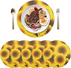 a plate with some food on it next to placemats and silverware in the shape of sunflowers