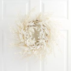 a white wreath hanging from the side of a door