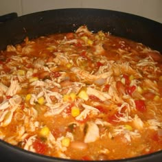 a pot filled with chicken, corn and tomato soup