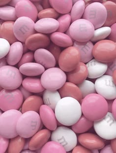 pink and white candy pebbles with the word m e n d s on them are shown in close up