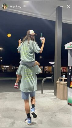 a man holding a child in his arms while walking through an empty parking lot at night