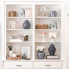 a white bookcase filled with vases and other items on top of it's shelves