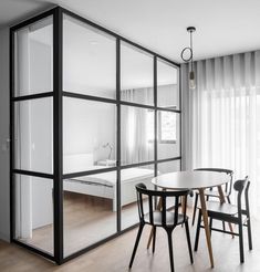 a dining table and chairs in front of a sliding glass wall