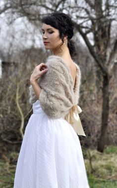 a woman in a white dress and fur stoler