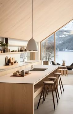 a kitchen with white counter tops and stools in front of a large open window