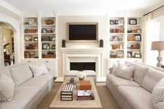 a living room filled with furniture and a flat screen tv mounted on the wall above a fire place