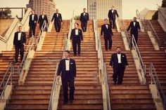 men in tuxedos are walking down the stairs