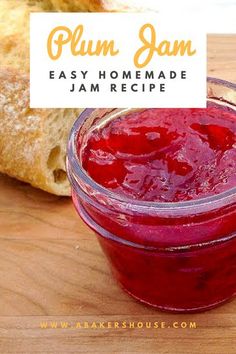 a jar of jam sitting on top of a wooden table next to a loaf of bread