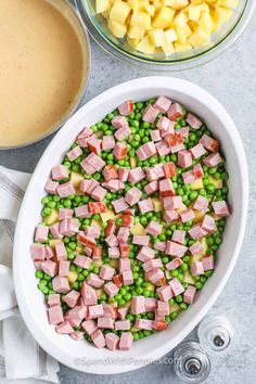 peas, ham and potatoes in a bowl next to the ingredients for this dish are ready to be mixed together