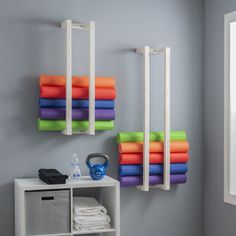 there are many different colored towels hanging on the wall next to each other in this room