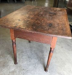 an old wooden table sitting in a warehouse