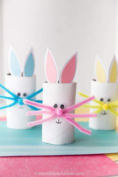 four toilet paper rolls with bunny ears on them and some colored streamers in the middle