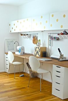 a desk with two chairs and a laptop computer on top of it in a room