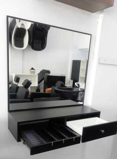 a black and white mirror sitting on top of a counter next to a drawer filled with shoes