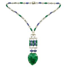 An outstanding Art Deco pendant necklace in highly characteristic colour and design. It is composed of blue and green chalcedony glass rounded baguettes throughout, highlighted with clear cut paste rectangular and square faceted stones. The striking pendant is made of moulded marbled green glass, in a stylised 'heart' design, with moulded patterns to emphasise the decoration. The necklace meets at the back, with a secure push clasp. The necklace is made from silvered metal and is either of Frenc Modern Green Necklace For Formal Occasions, Formal Glass Pendant Necklaces, Formal Glass Pendant Necklace, Glass Pendant Necklace For Formal Occasions, Glass Pendant Necklaces For Formal Events, Art Deco Pendant Necklace, Green Chalcedony, Art Deco Pendant, Blue Chalcedony