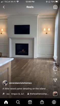 an image of a living room with wood flooring and white walls on the phone screen