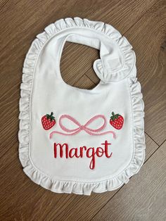 Strawberry Theme Baby Bib Your little one will look so cute in this adorable strawberry theme baby bib. The bib is soft and comfortable and 100% cotton. I also make a matching handmade bubble! The bubble is embroidered in the same strawberry design with your little one's name.  I make the bubble in sizes NB-24mo. The bib is one size and fits babies very comfortably.  Due to the personalization, I do not accept returns on this item. However, if you have any questions, concerns, or issues, please message me. Cute White Bib For First Birthday, Cute Cotton Bib As Gift, Personalized White Birthday Bib, Cute White Bib Front Bib, Cute Pink Bib As A Gift, Cute Pink Bib As Gift, Cute White Bib For Playtime, Personalized Bib For First Birthday, Cute Personalized Birthday Bib