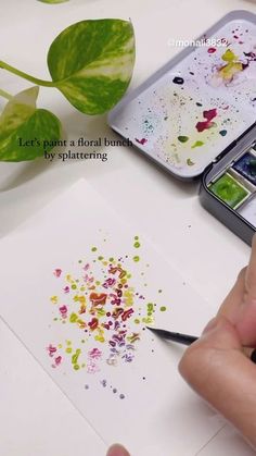 a person is painting with watercolors on paper