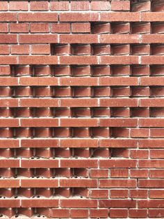 a red brick wall that is made out of bricks and has holes in the middle