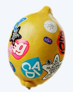 a close up of a lemon with stickers all over it's face and body