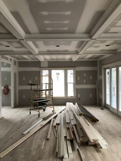 an empty room with unfinished wood floors and windows