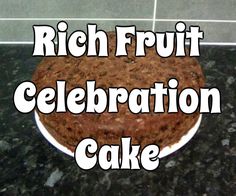 a cake sitting on top of a counter next to a white plate with the words rich fruit celebration cake